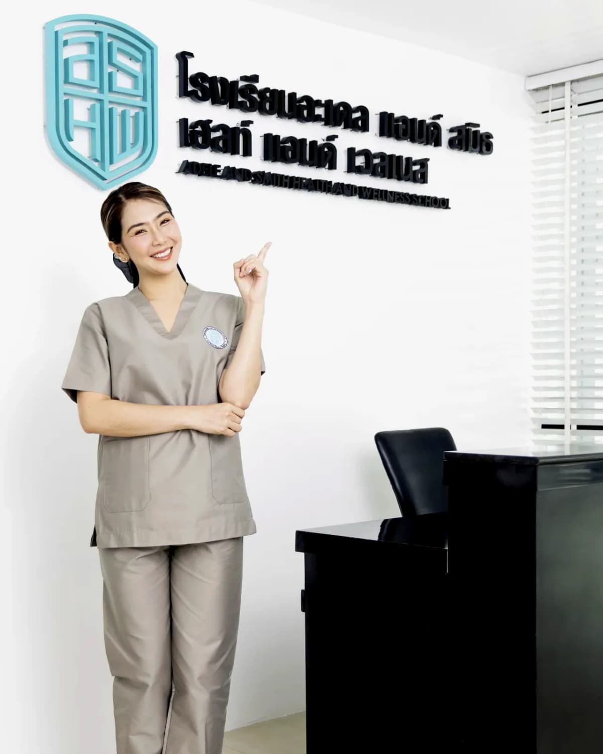 ครูผู้สอนหน้าป้ายโรงเรียน Adele & Smith Health and Wellness
